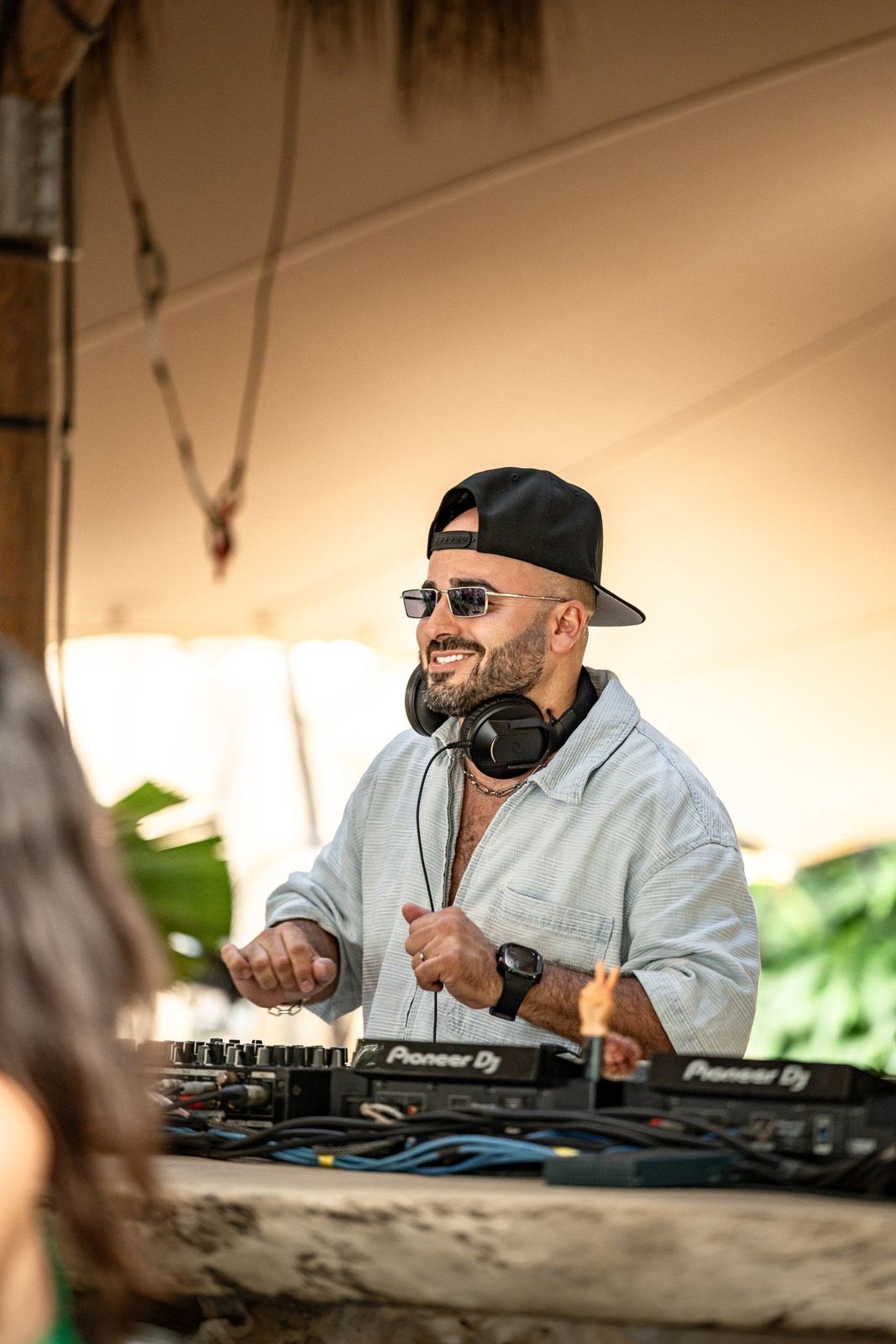 ERAN smiling behind the decks at a daytime beach party