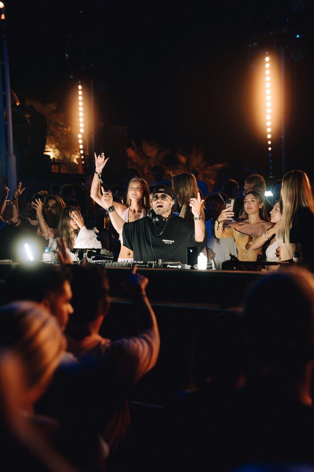 ERAN behind the decks with the crowd’s hands up at an open-air night party